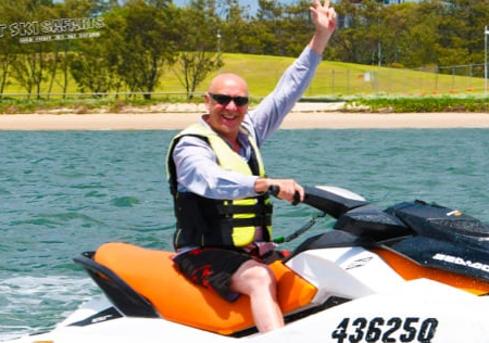 A Middle Aged Man with Shades Enjoying the Jet Ski
