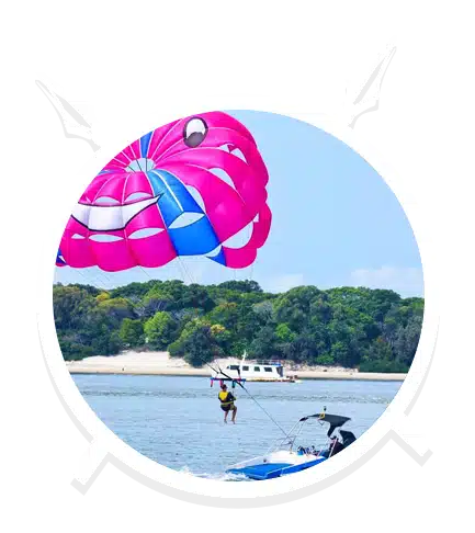 A Man Parasailing with Pink and Smiley Balloon in Main Beach, QLD